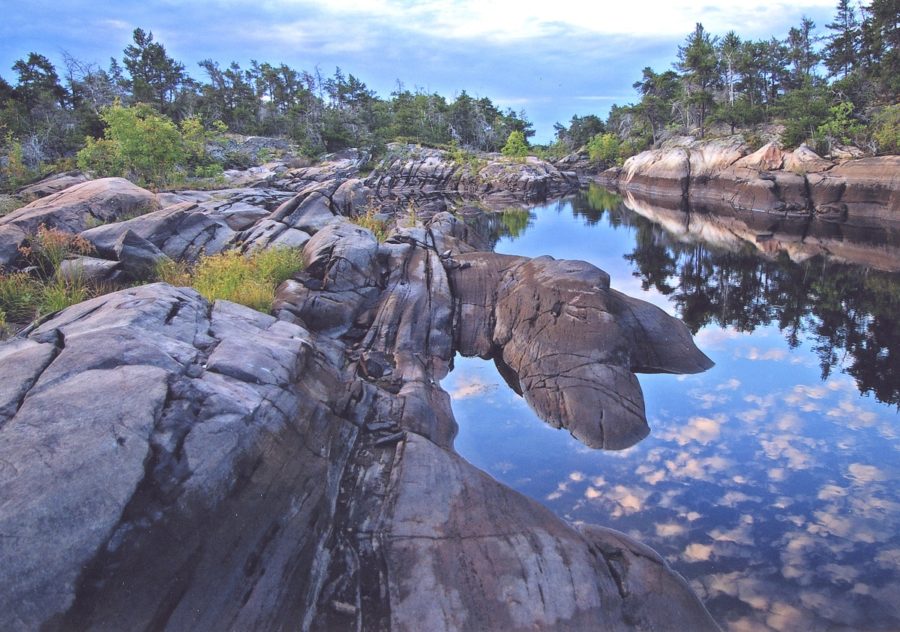 Rocks and water reflecting blue sky overhead