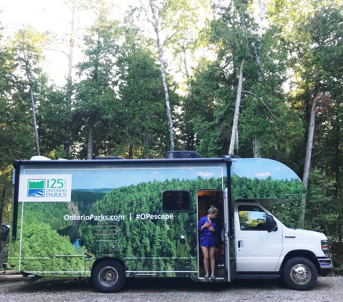 Side view of RV with woman in the door