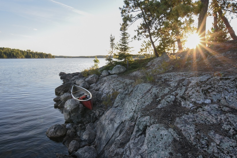 Canoe on the shore during sunset.