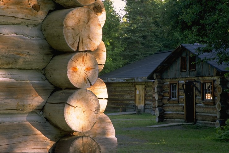 Log cabin with corner of additional log cabin in the foreground