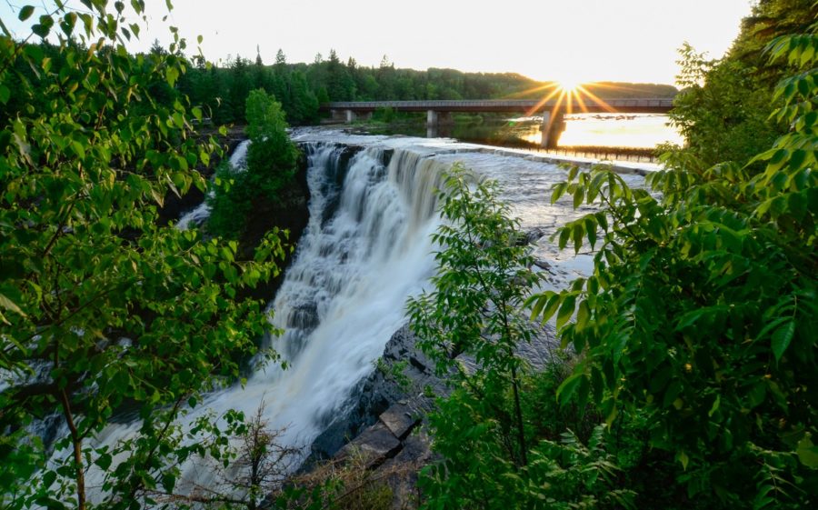 View of water fall from amongst some brush at sunet