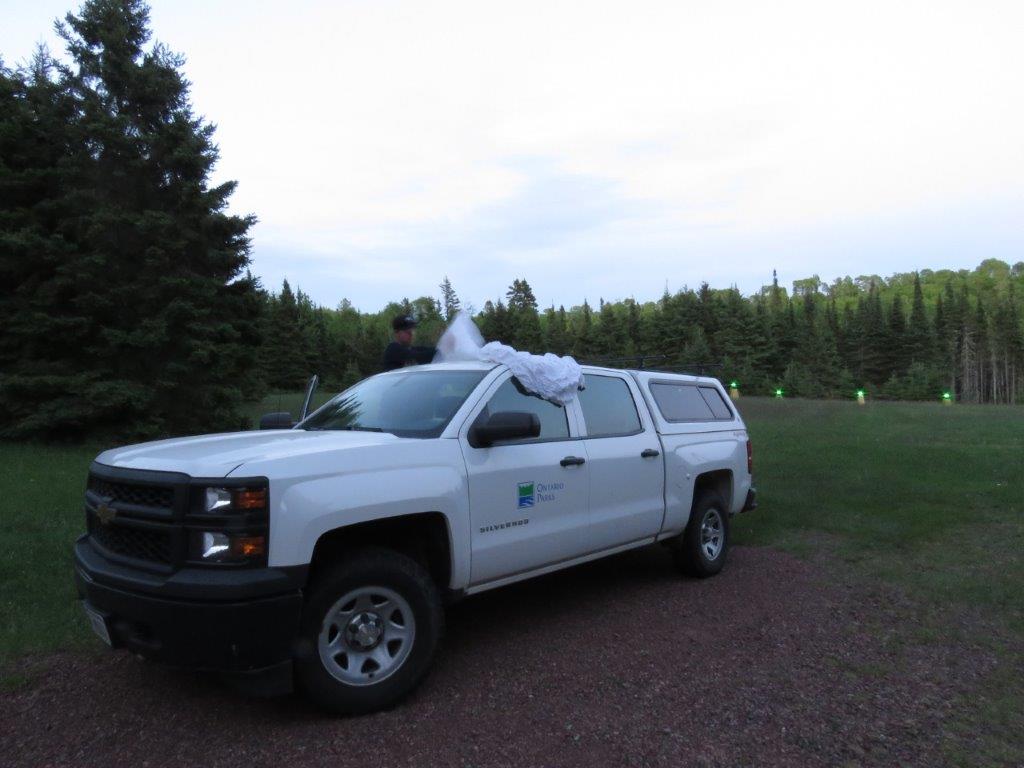 White truck in a field at dusk