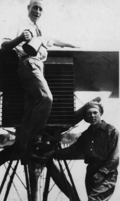 Black and white photo of two guys with a plane