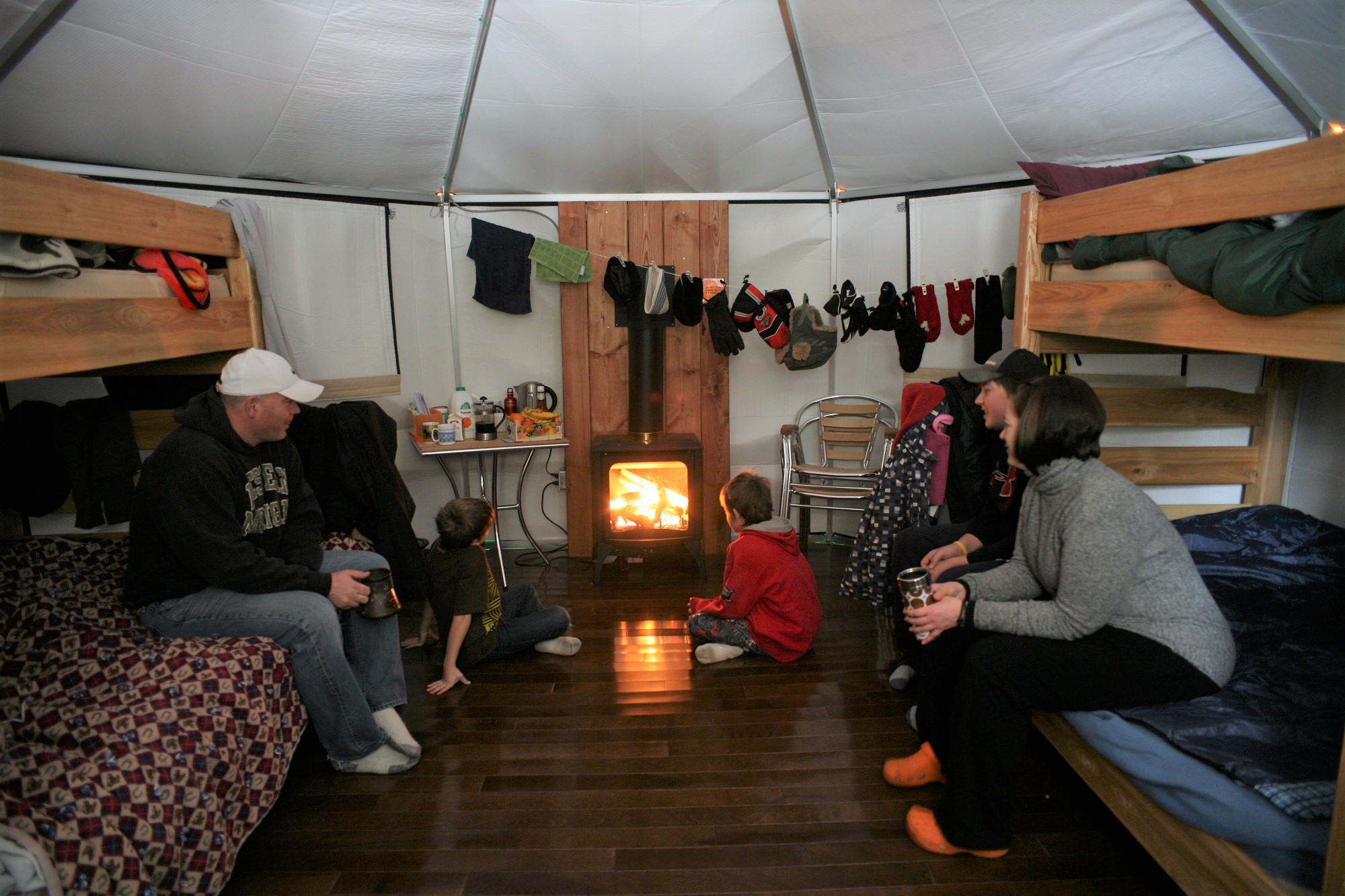 Family sitting around a fire in a yurt