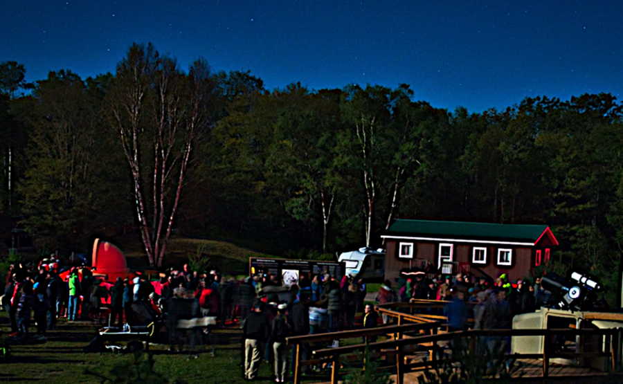 group in observatory field at night under starry skies