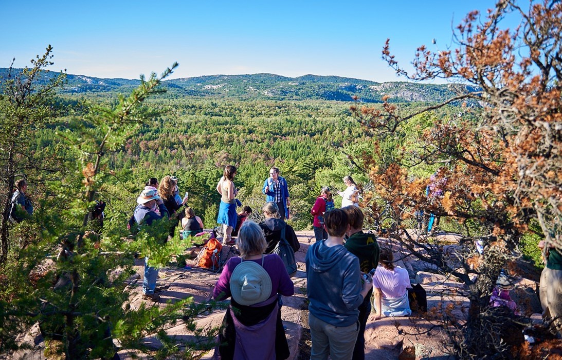 hikers on the summit of the Granite Ridge Trail overlooking forest