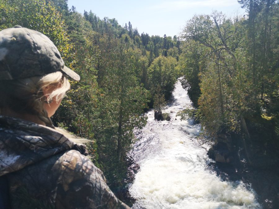 woman looking onto quickly-moving river