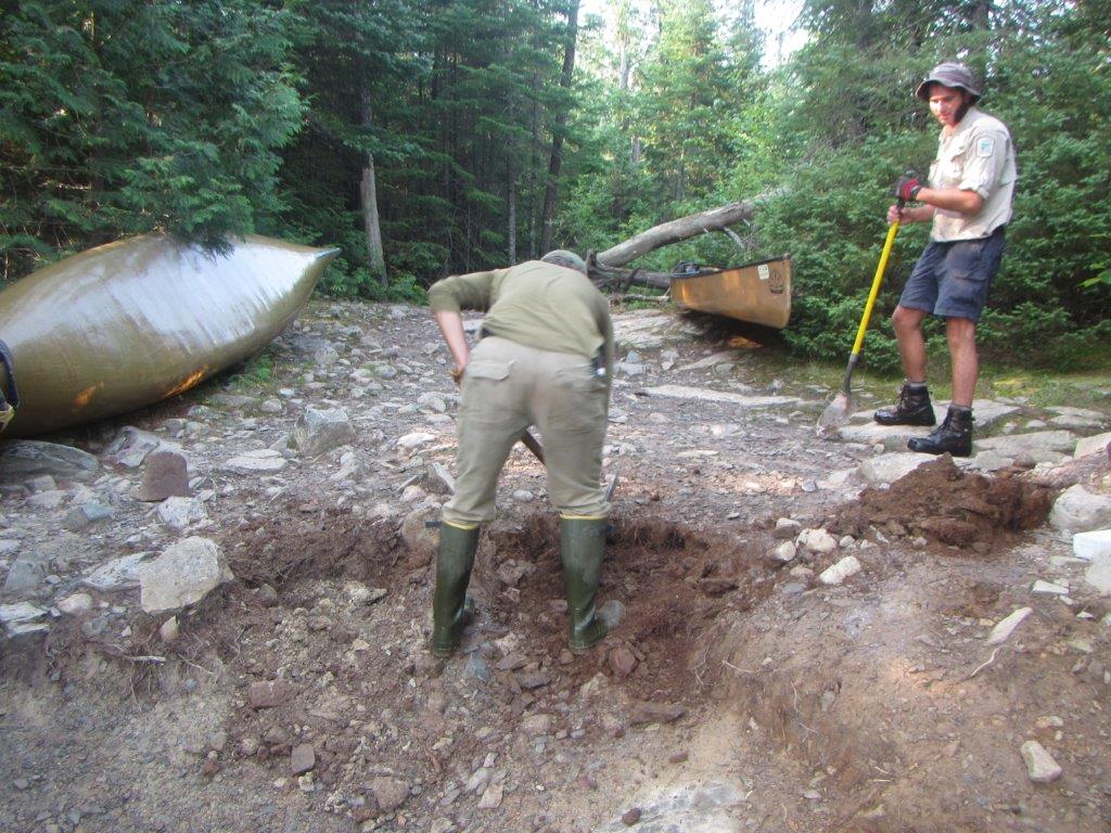 two men digging up rocks and dirt