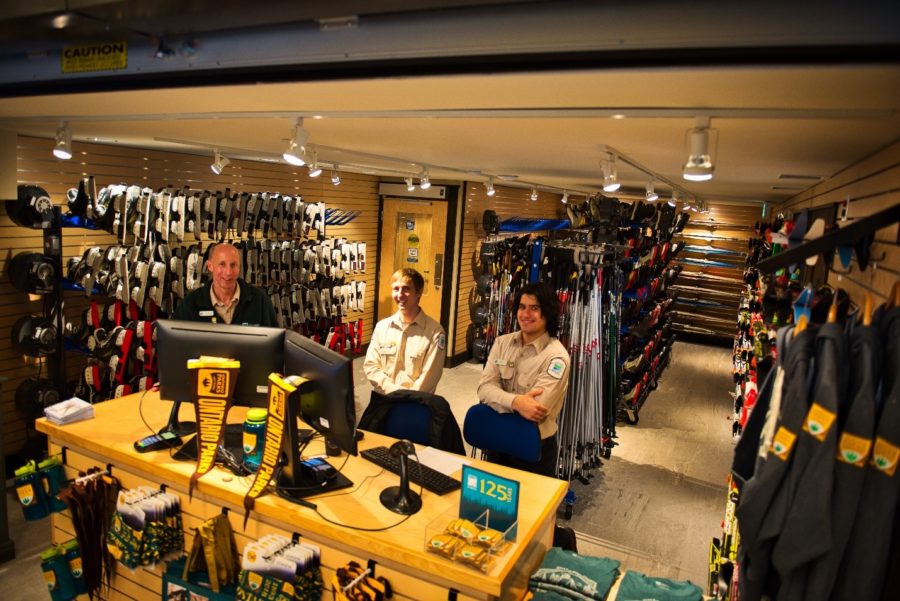 employees in rental shop surrounded by winter equipment