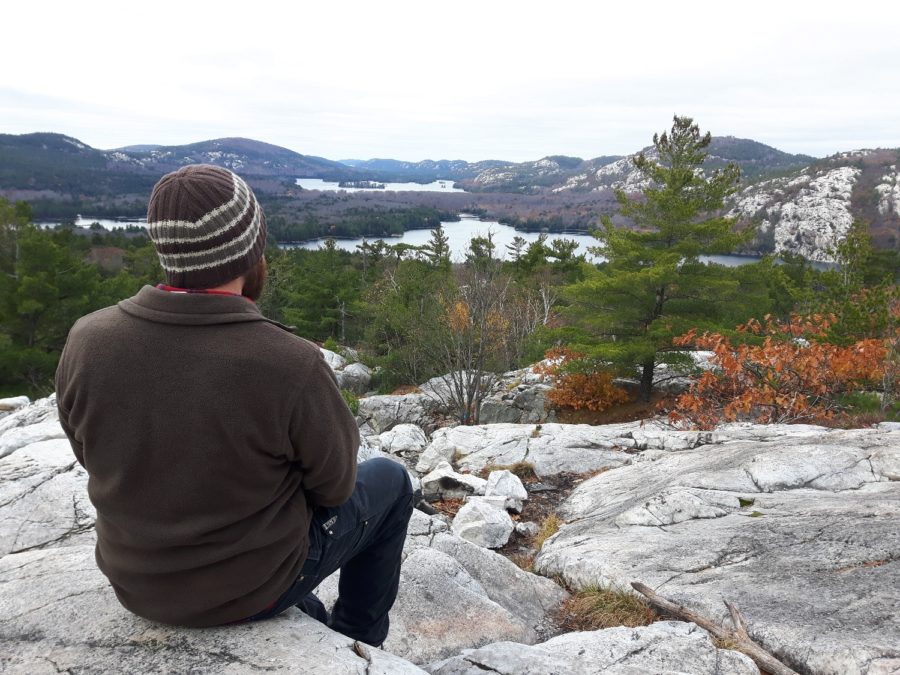 hiker sitting on rocks overlooking Killarney vista