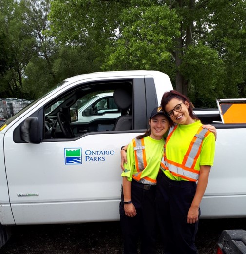 two staff members in front of truck