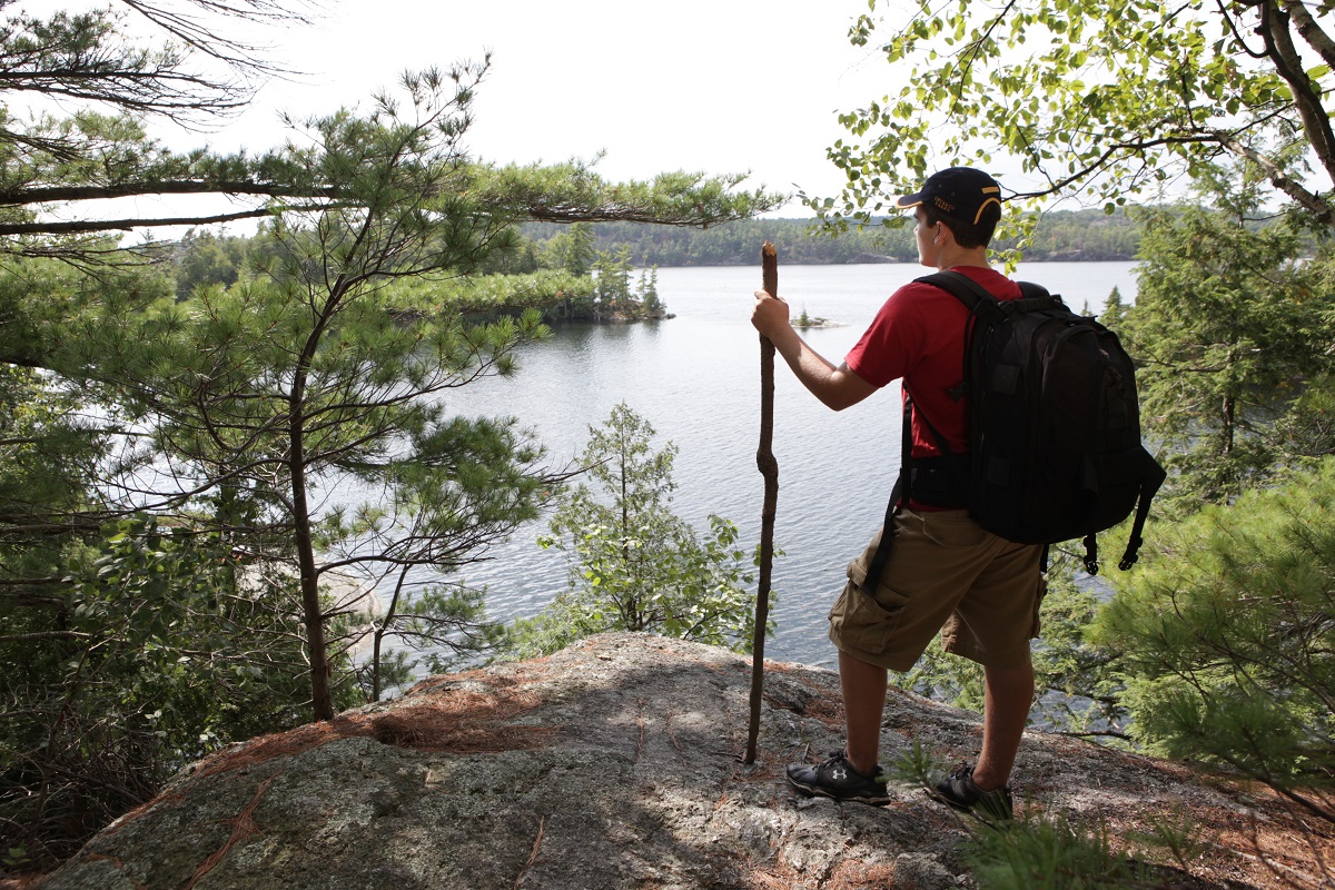 person standing on trail with hiking stick