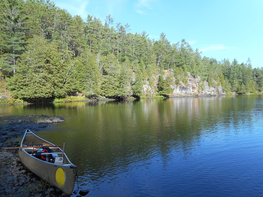 canoe resting on shore of lake