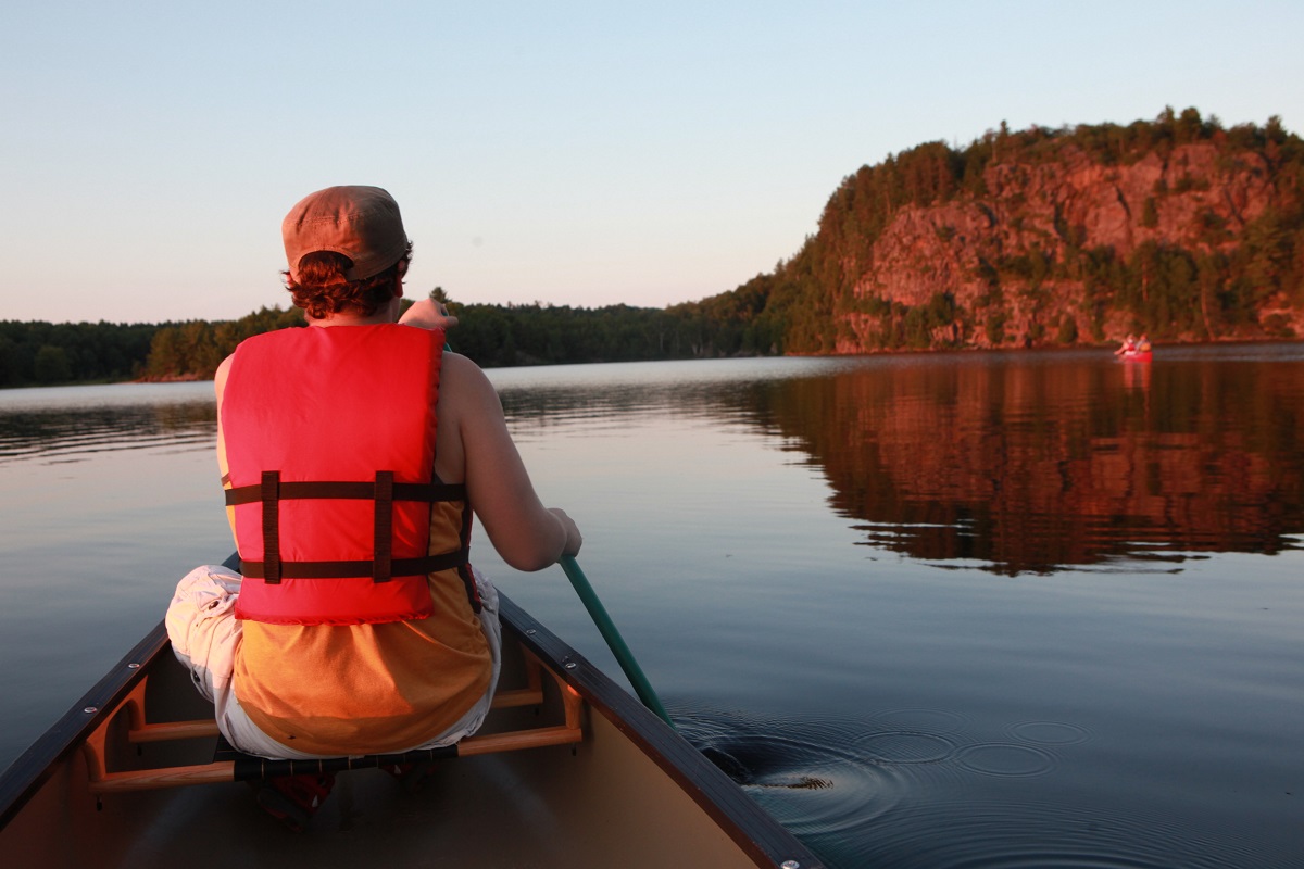 person canoeing on lake