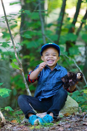 child sitting near tree