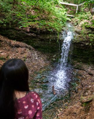 Girl looks out at waterfall