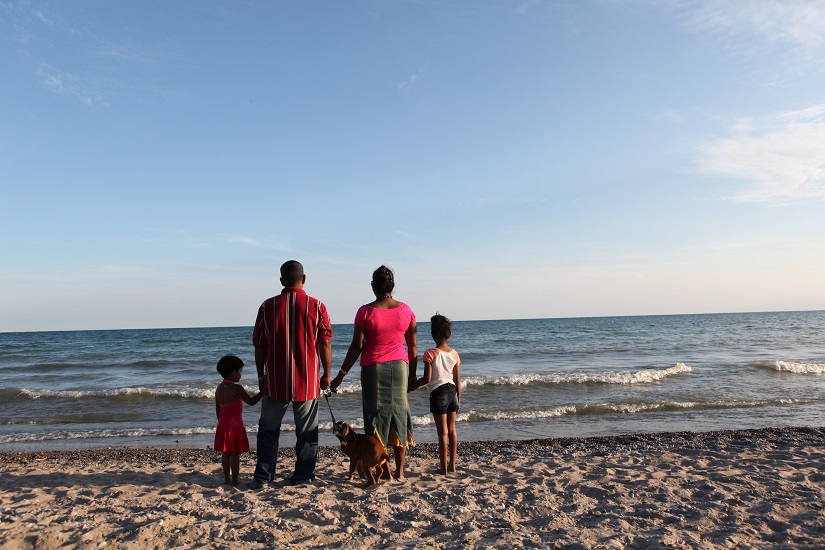 Family on beach looks out at water