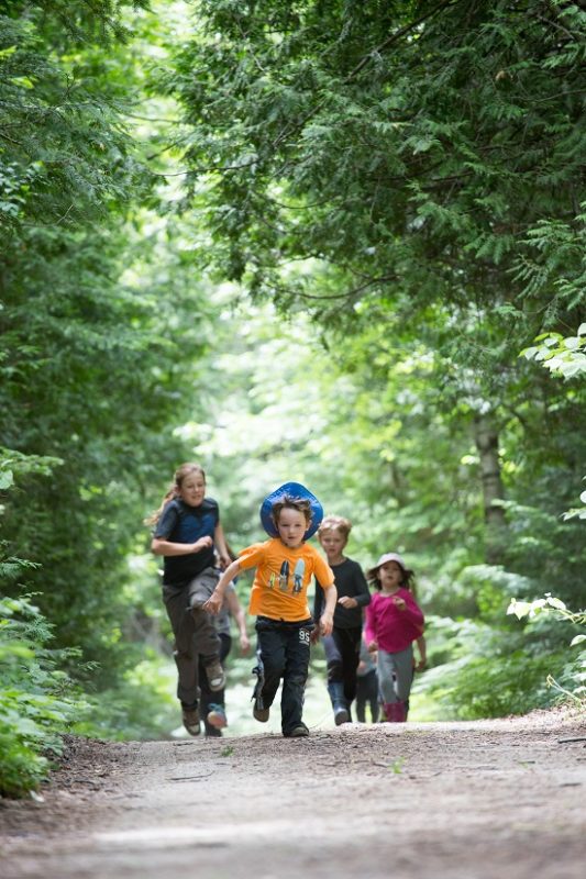 Children running on trail towards camera