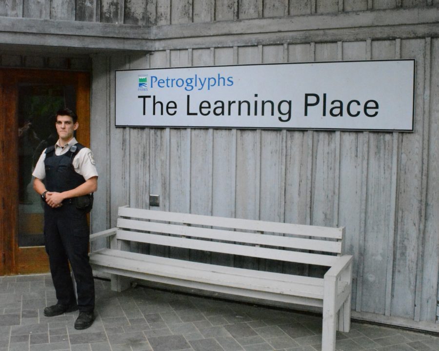 warden standing in front of building w sign