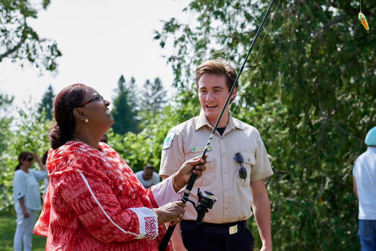 woman fishing with park staff supporting