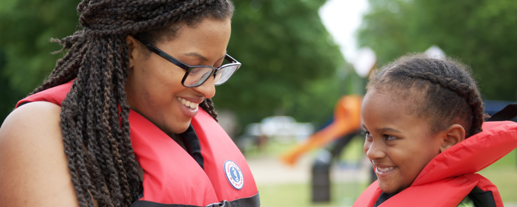 Mother fastens up PFD, lifejacket on child