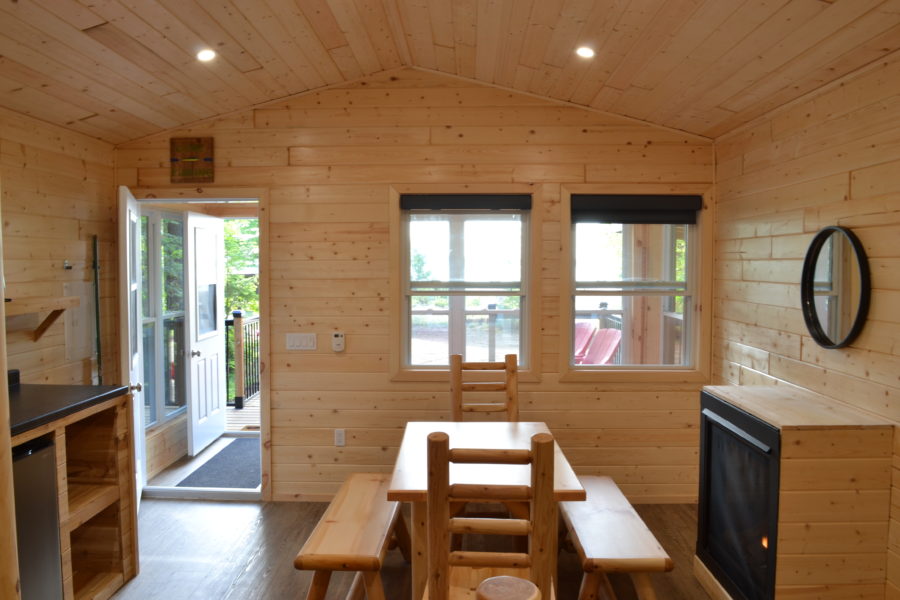 View from inside the cabin showing the fireplace and screened in porch.