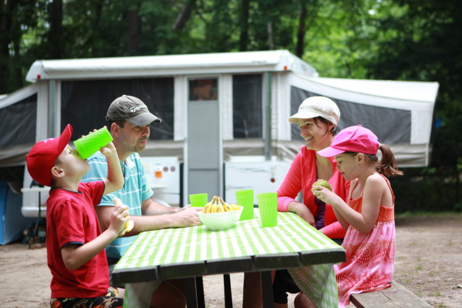 Family at picnic table eating lunch using reusable dishes.