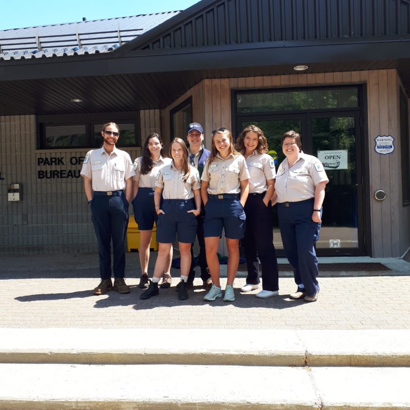 staff standing in front of gatehouse