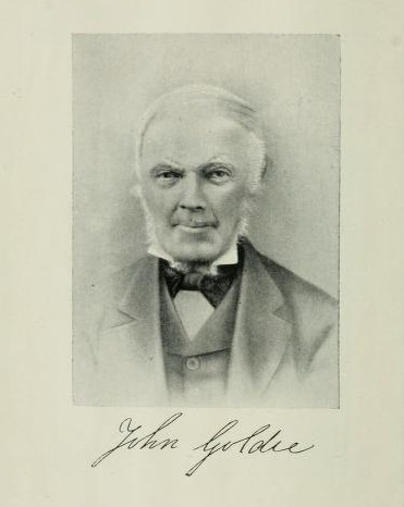 A black and white photo of John Goldie with his signature beneath.