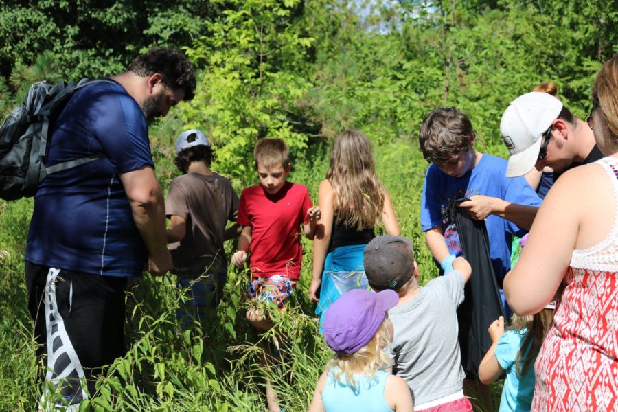 Visitors to Emily helping out in an invasive species program where they learnt how to identify and remove harmful plants.