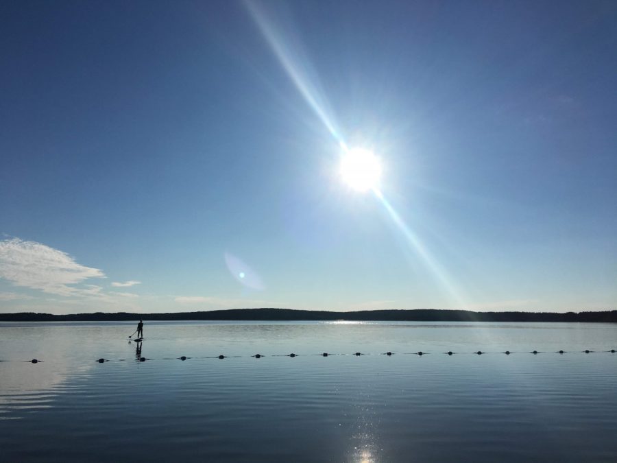 Pictured is the blue swimming area with a paddleboarder in the distance.