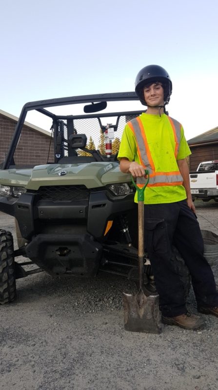 staff in front of gator holding rake