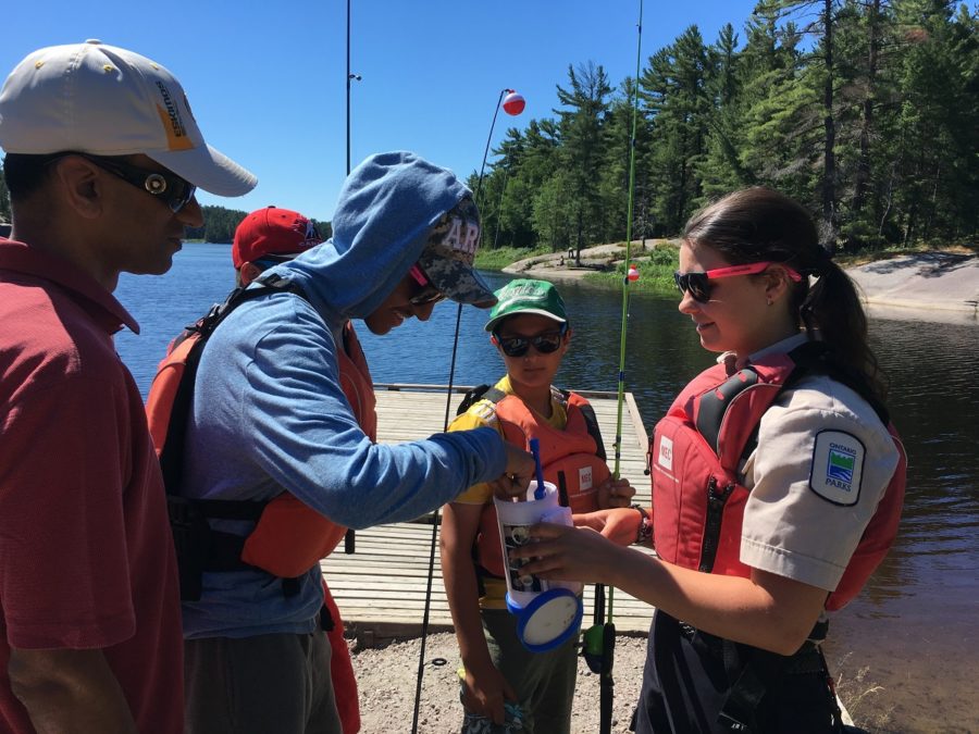 A staff member assisting with the learn to fish program.