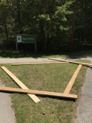 Picture shows staff measuring out the floor bed using wood planks on the grass surface.