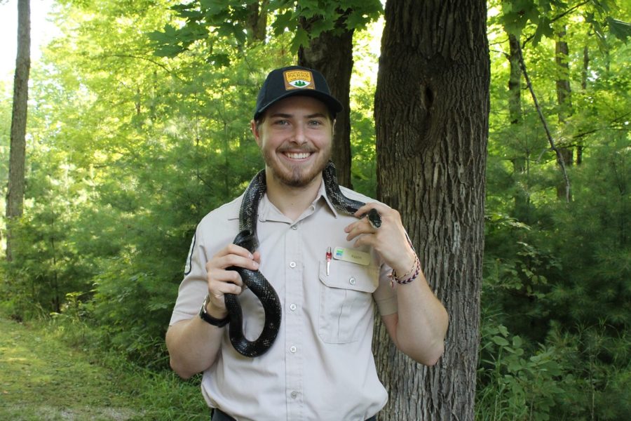 uniformed ranger holding snake on shoulders