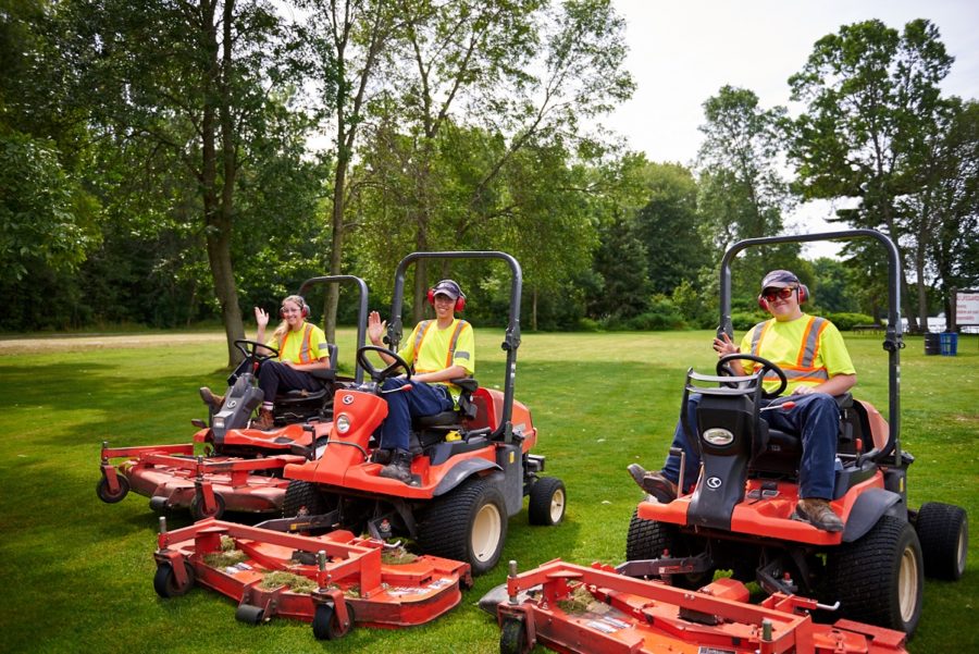 summer students cutting grass