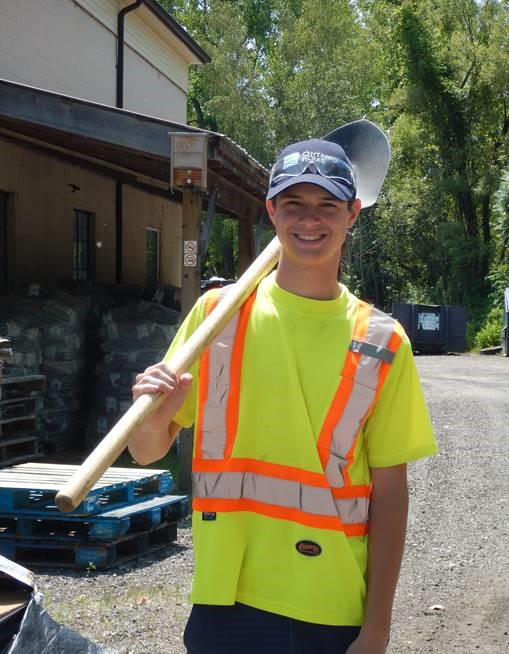 fluorescent-shirted staff holding shovel