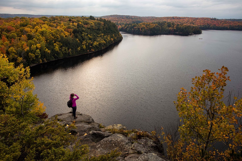 Hiker at a lookout with fall colours.