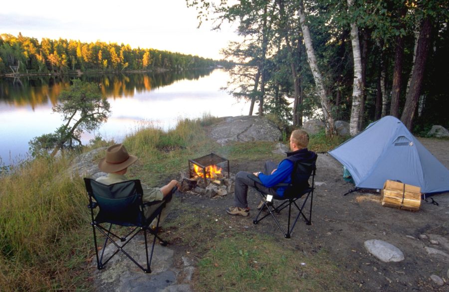 Two campers sitting by the fire.