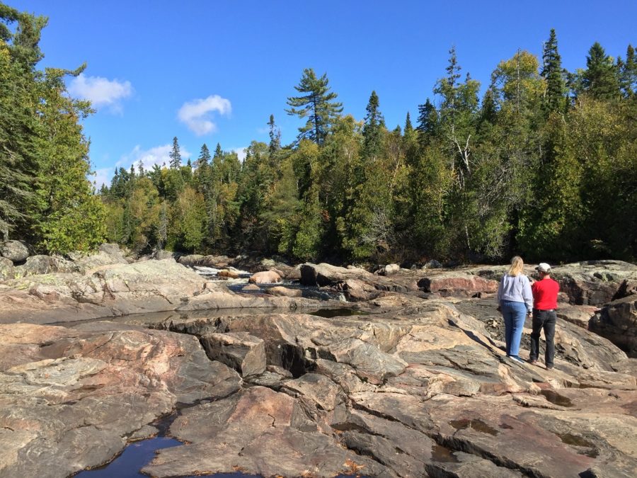 rocky shoreline with two hikers