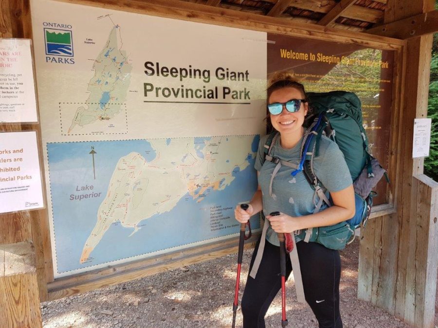 Standing in front of trail sign.