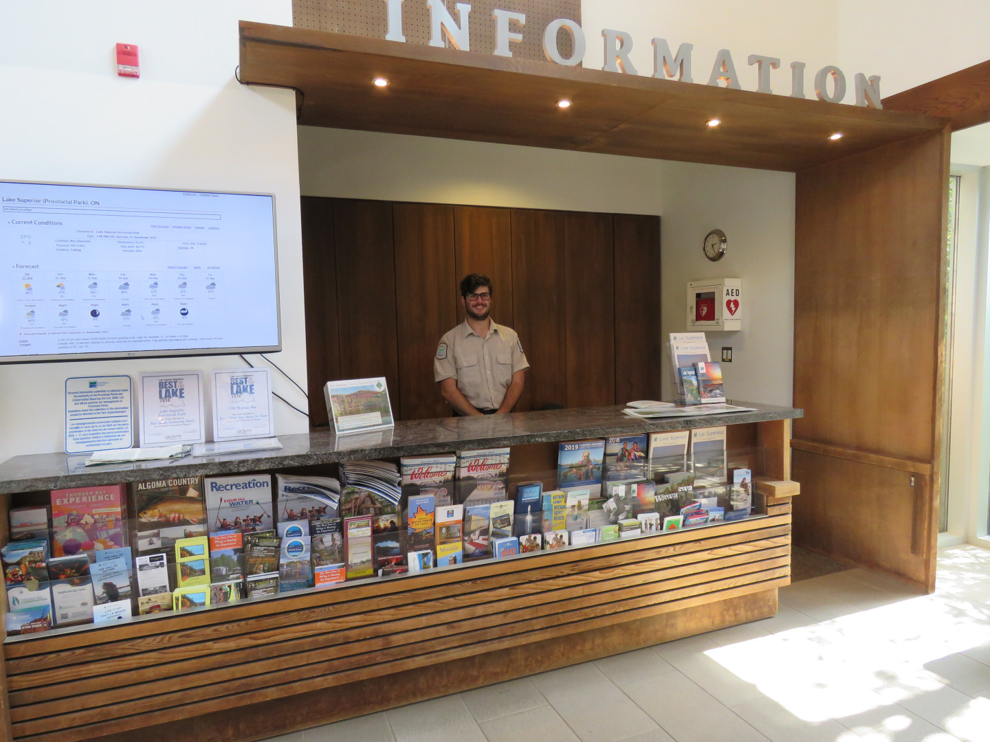 Staff member standing behind information desk.