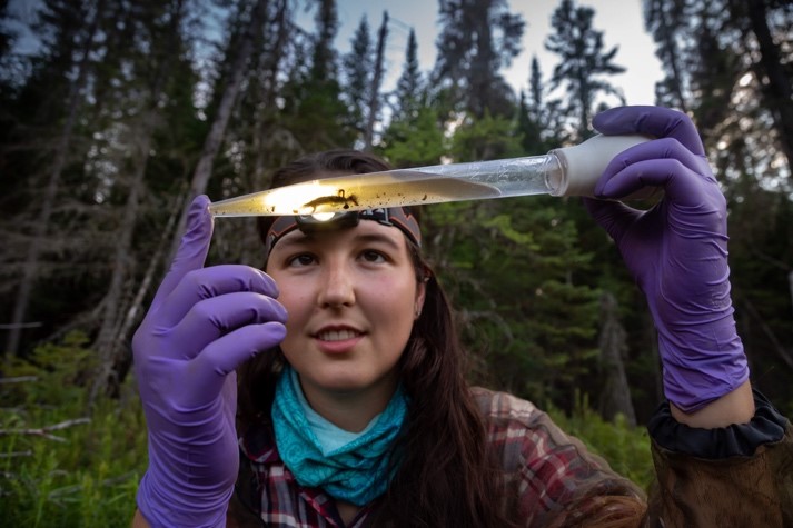 woman holding turkey baster with plant materials inside