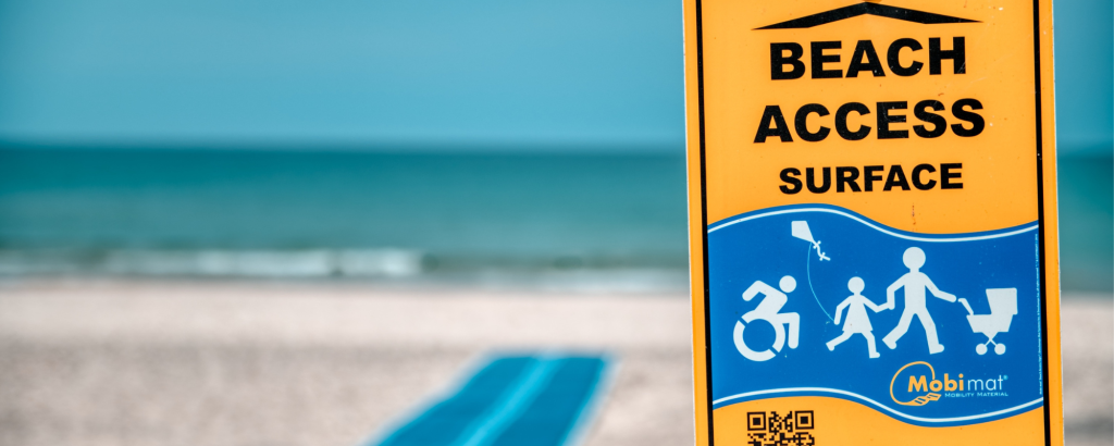 An accessible beach mat with a sign