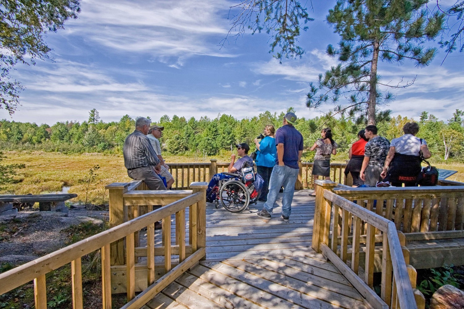 group of hikers at lookout boardwalk point over wetland