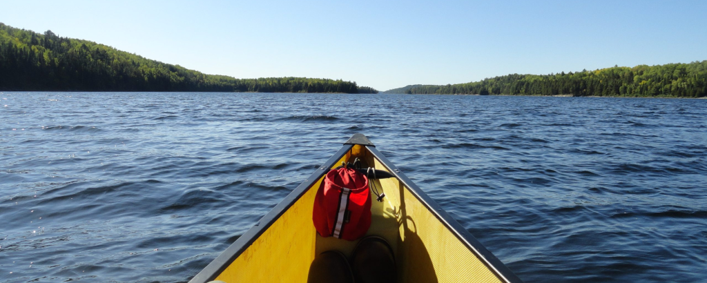 View from the bow of a canoe on a lake