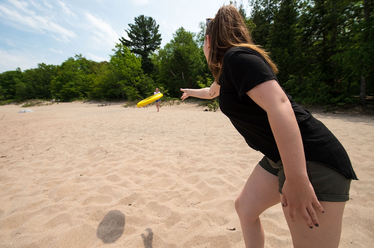 two people playing frisbee on beach