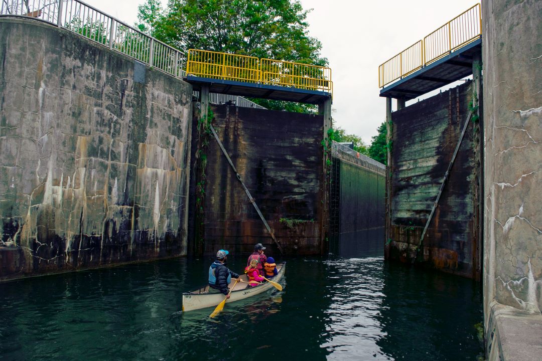 two people canoeing through canal