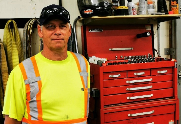 staff standing next to tool box