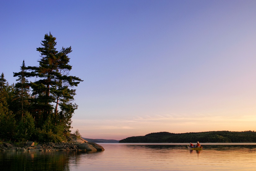 Paddling a canoe on a lake in early evening